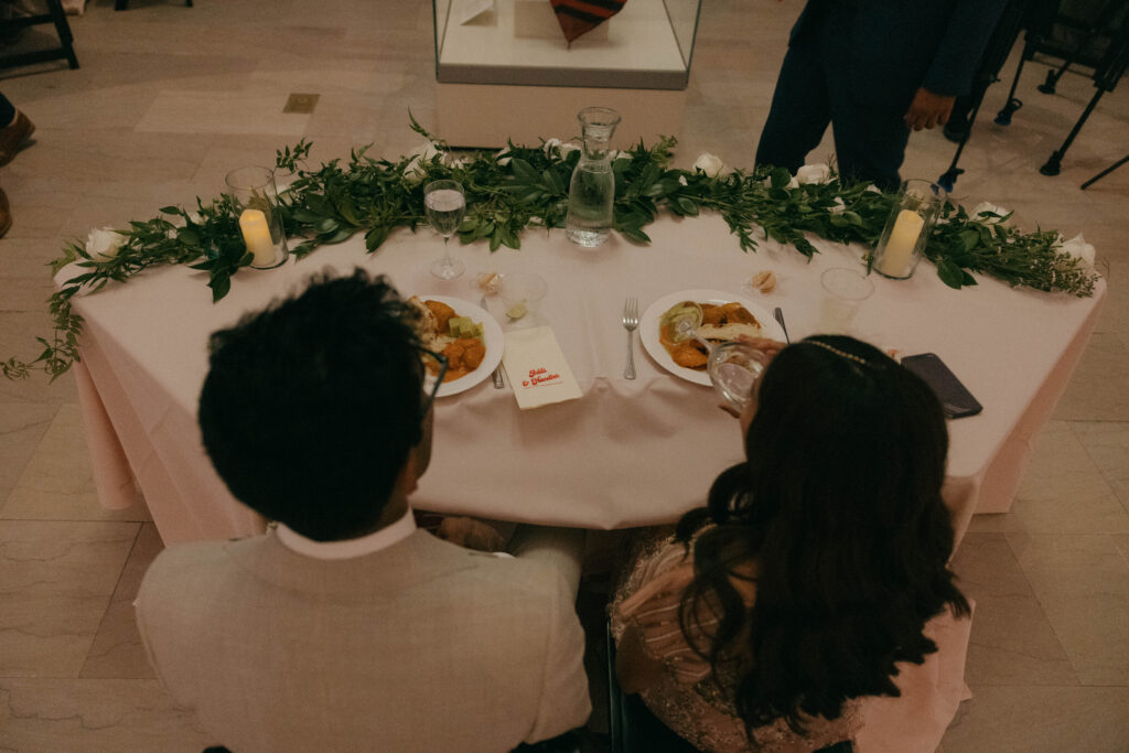 bride and groom eating Indian food during wedding dinner