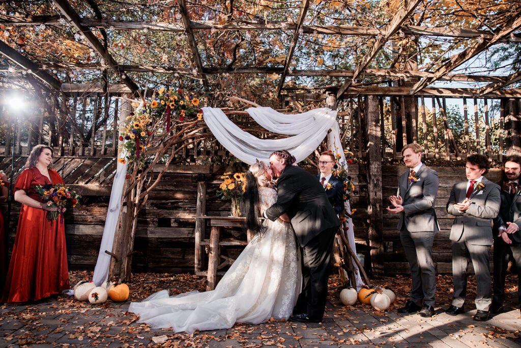 bride and groom ceremony kiss at October wedding at The Gardens