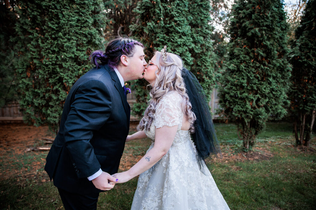 bride and groom kissing after first look at October wedding at The Gardens