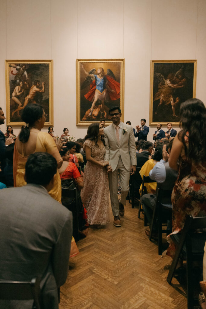 bride and groom recessing down the aisle at art museum ceremony