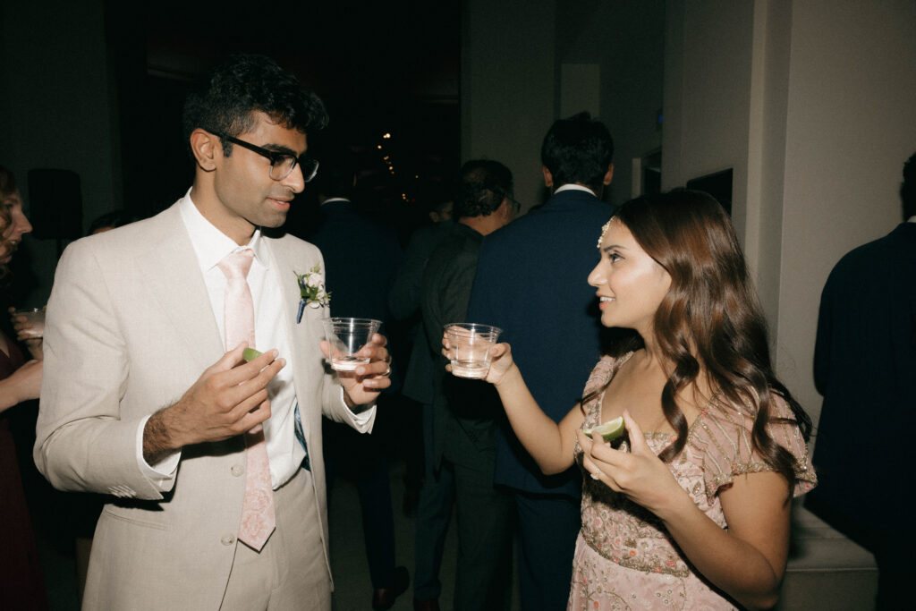 bride and groom taking a shot of alcohol during wedding reception 