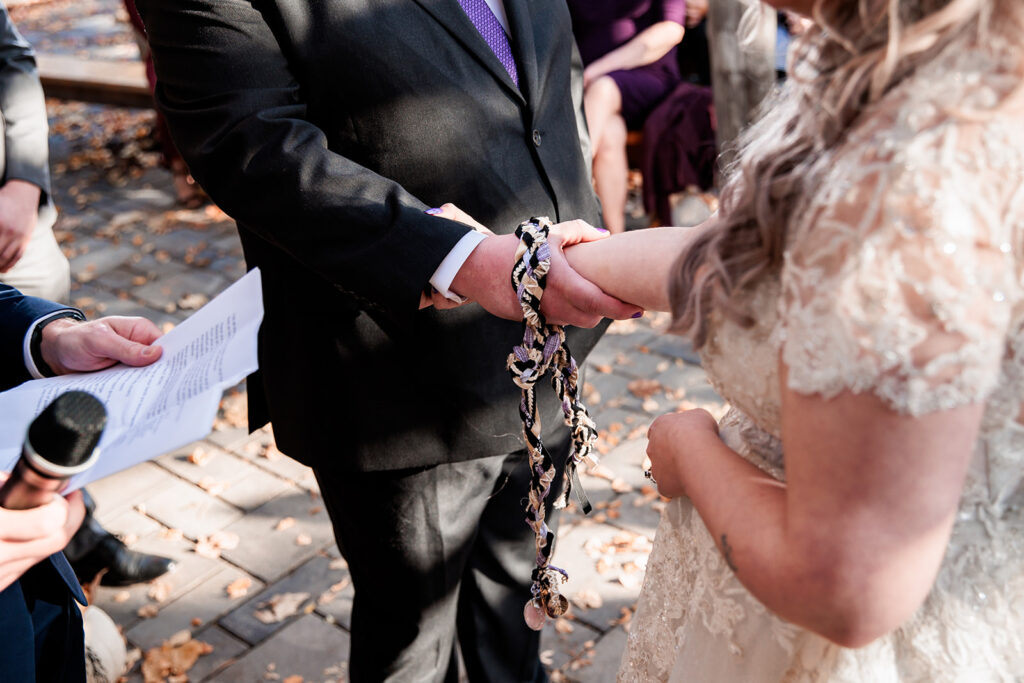 bride and groom doing unity tying ceremony at October wedding