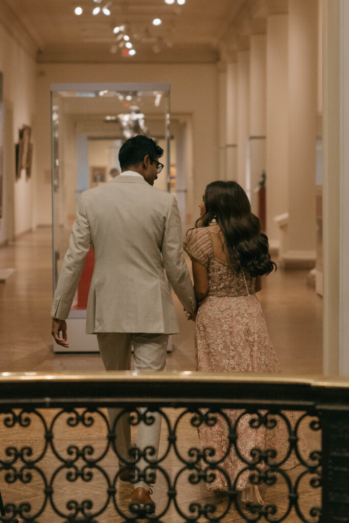 bride and groom walking down the halls of art museum