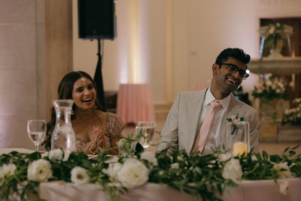 bride and groom laughing reacting to speeches during reception