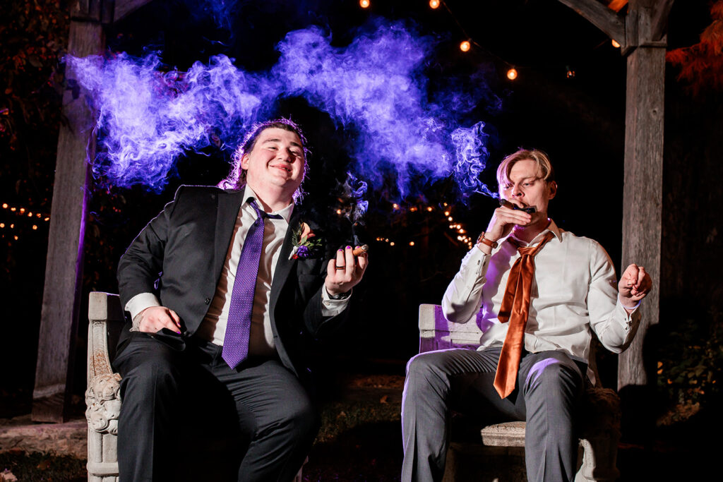 groom and groomsmen smoking cigar with back-lit smoke floating