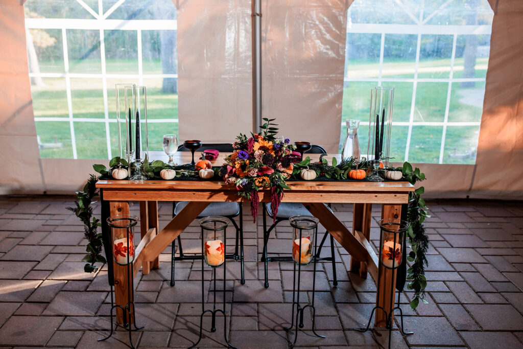 fall wedding sweetheart table with sunflowers and pumpkins