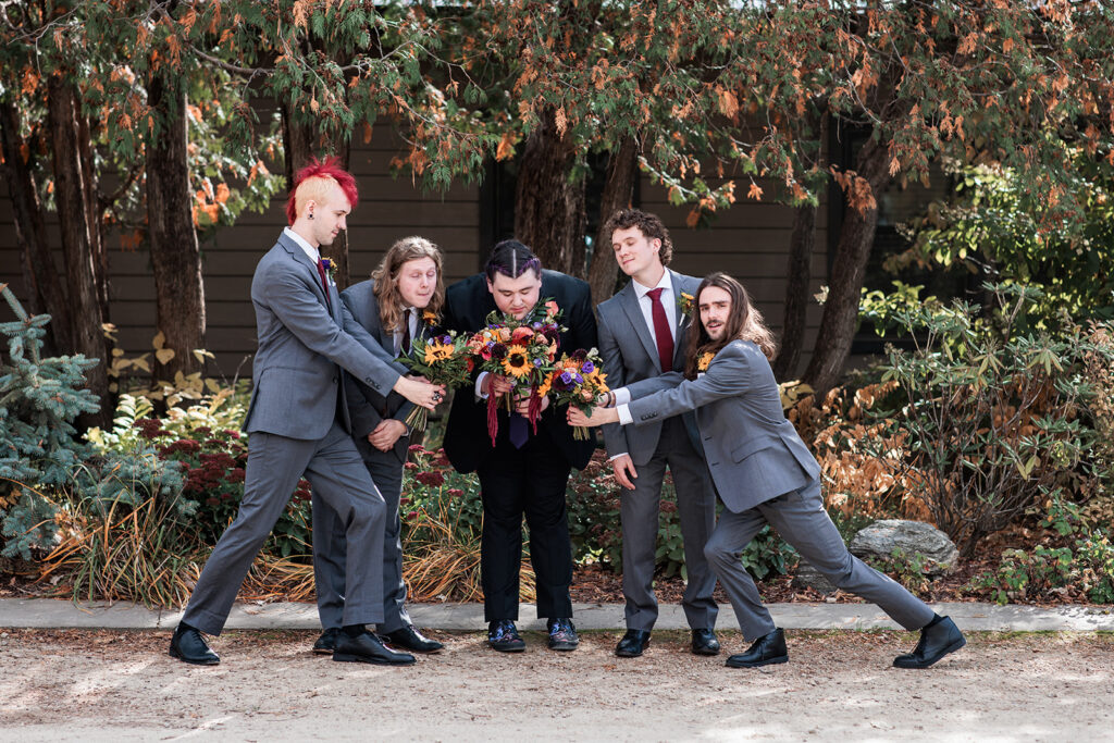 groomsmen funny portrait smelling bouquets