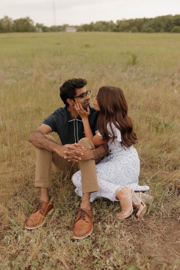 Bride and groom sitting in grass engagement photo