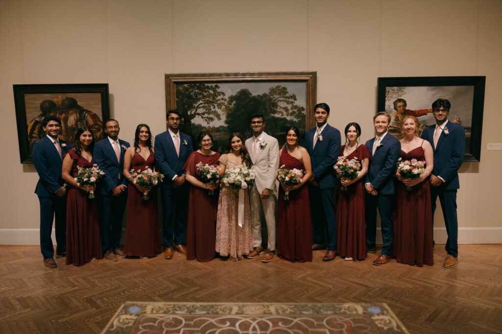 wedding party group photo posing in gallery of art museum