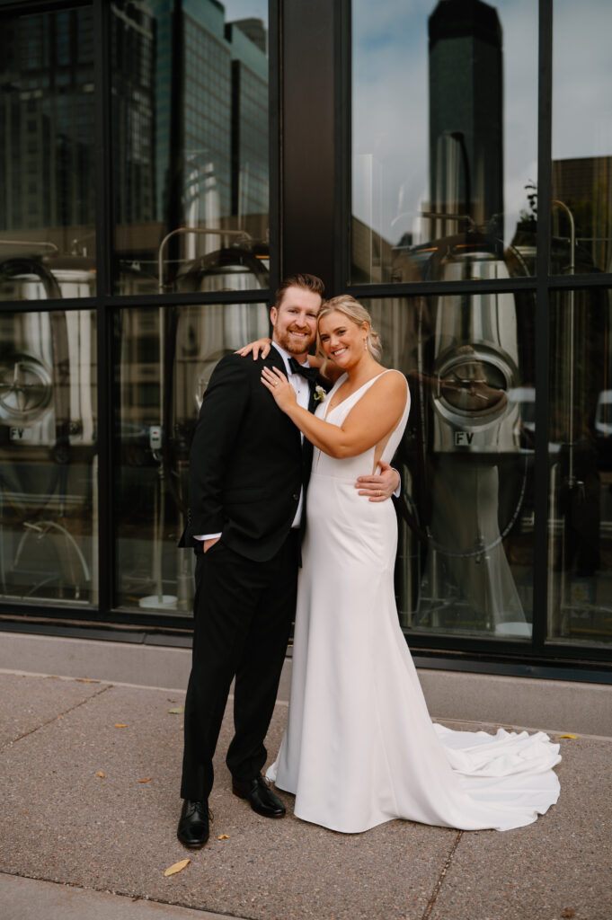 bride and groom causal formal portrait against window wall