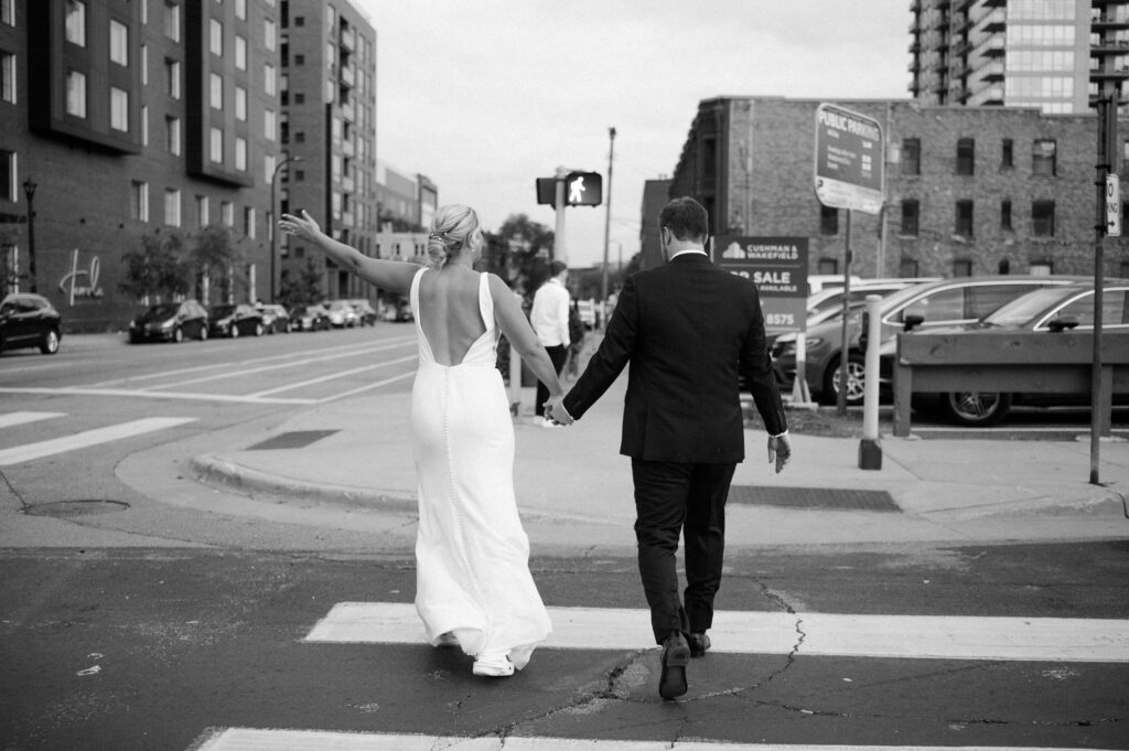 bride and groom cheering crossing street