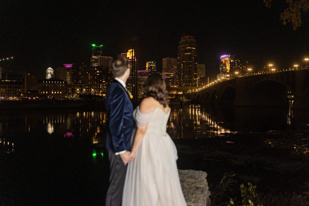 bride and groom admiring night views of Minneapolis skyline