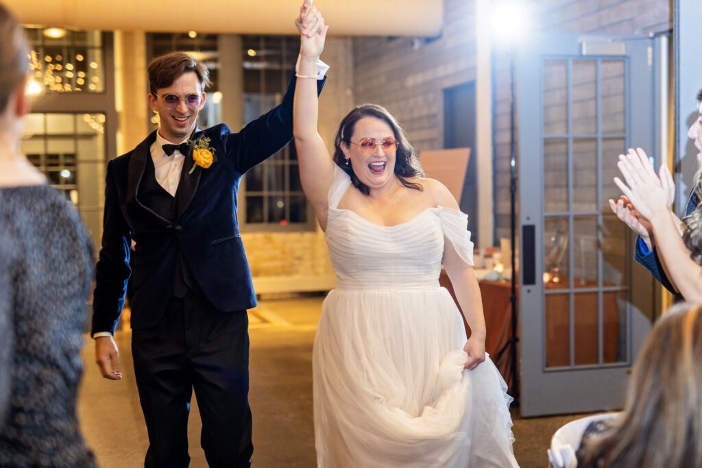 bride and groom grand entrance cheering wearing sunglasses