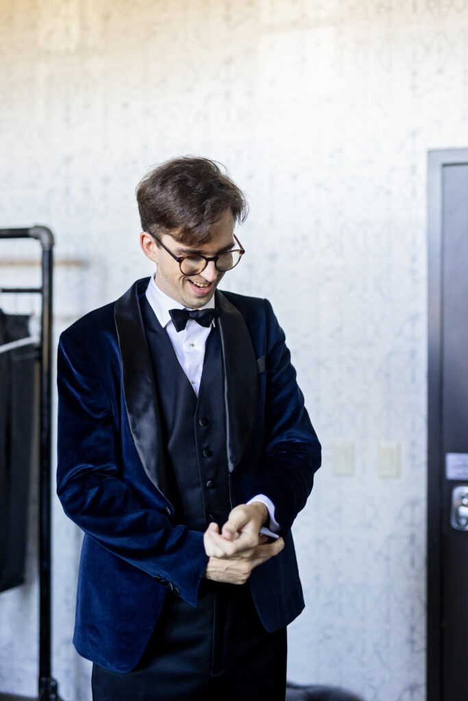 groom putting on velvet blue suit