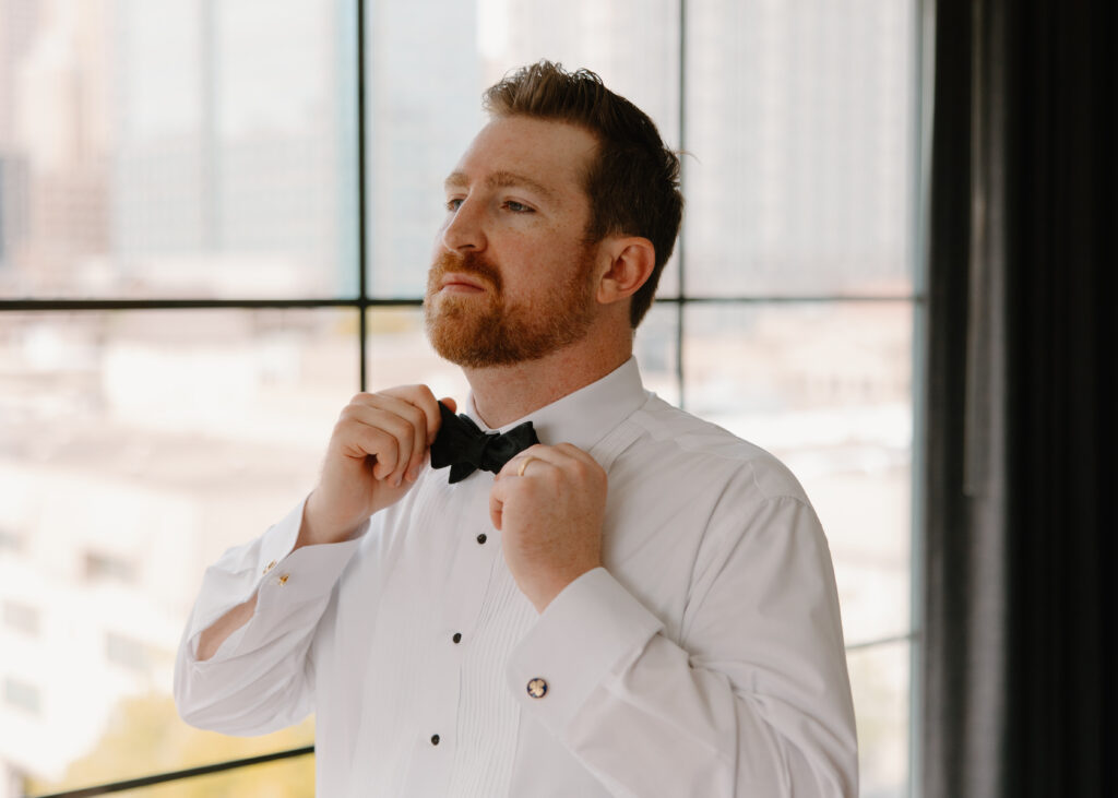 groom tying bowtie details