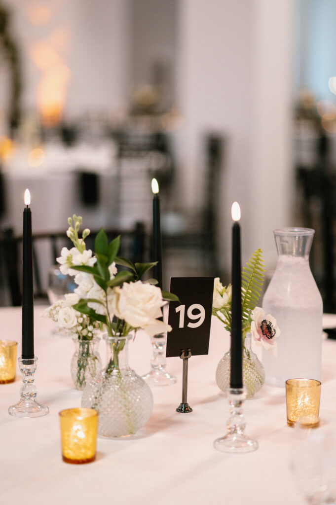 black taper candles and gold votive center piece at wedding reception