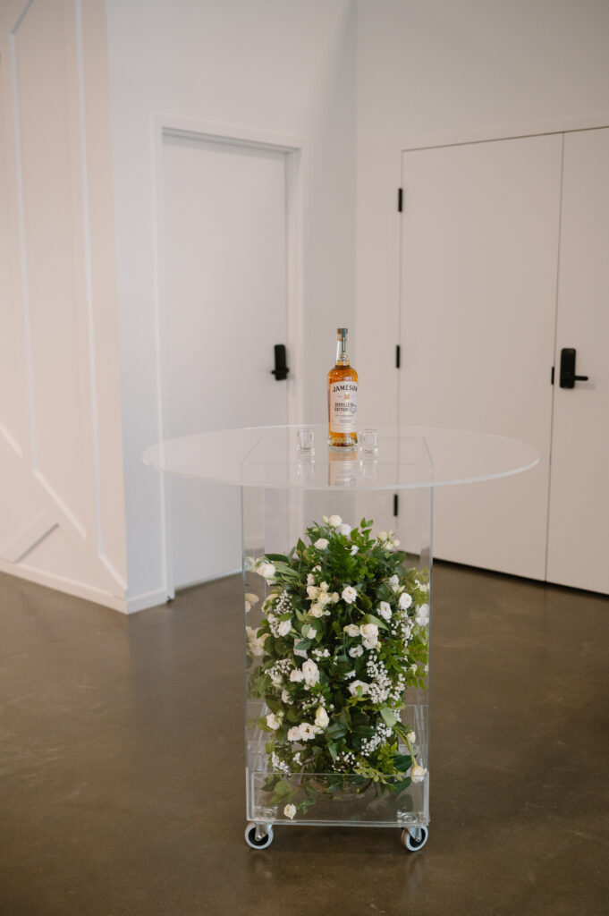 acrylic table filled with white florals and greenery