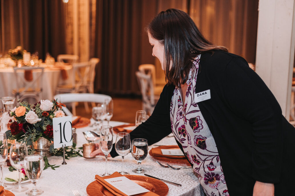 Wedding planner decorating reception tables