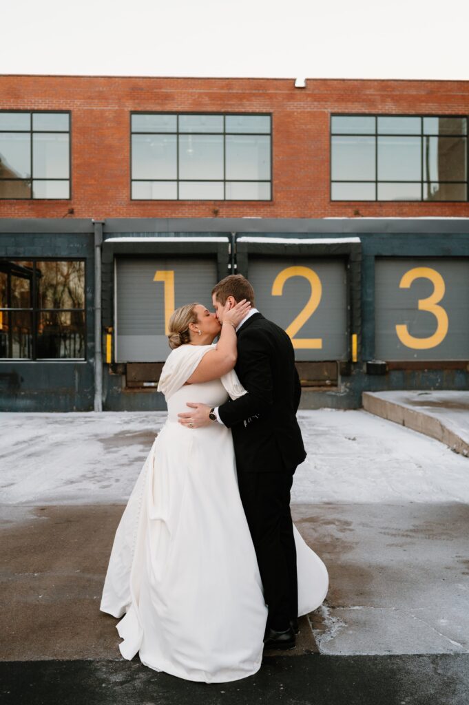 bride and groom kissing at winter Urban Daisy wedding