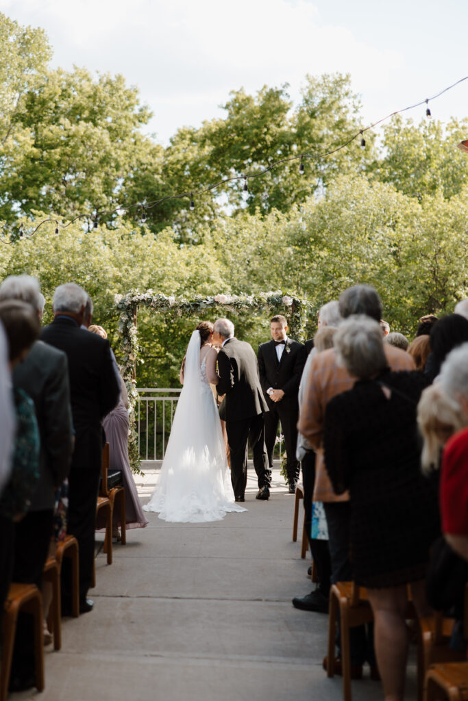 Outdoor ceremony recessional with bride and groom walking back up the aisle.
