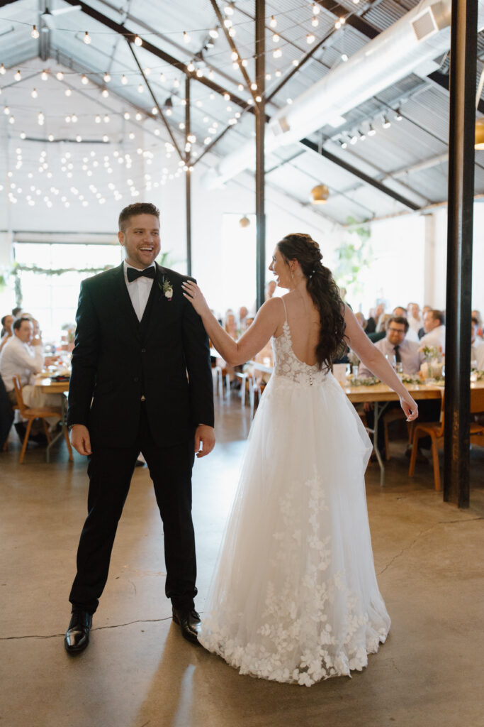 Bride and groom walking hand in hand down the aisle at their reception.